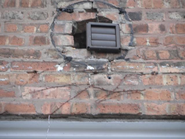 The opening in the brick is way to big for the exhaust fan vent pipe. "Joliet Home Inspection photos"