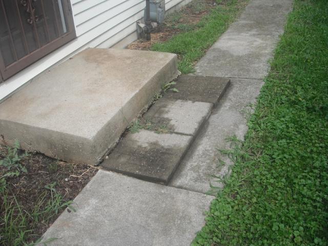 Concrete block on concrete walkway. Tripping Hazard. "Hickory Hills Home Inspection Photo"