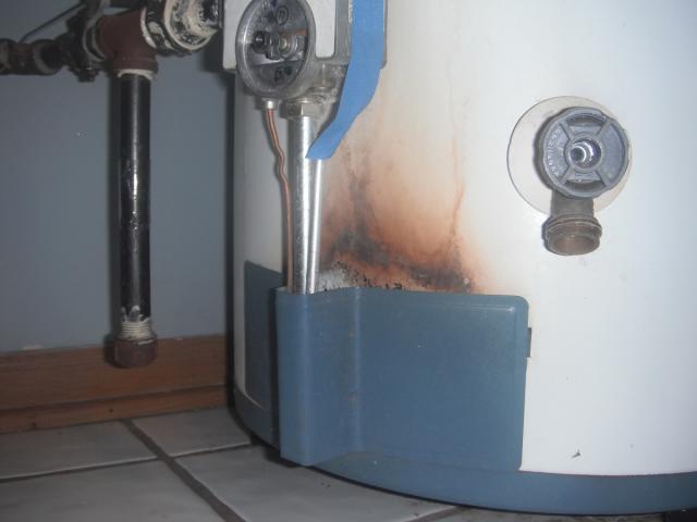 Signs of flame roll out on water heater.Knob missing also. Safety hazard. "Oak Park Home Inspection Photo"