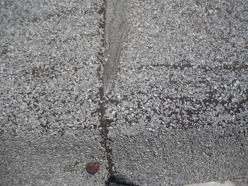 The asphalt roll roofing is cracked and very deteriorated. A roofer is needed. "Homer Glen Home Inspection Photos"