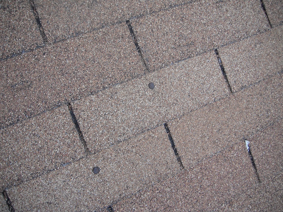 Worn roof shingles with exposed nails. "Orland Park Home Inspector"
